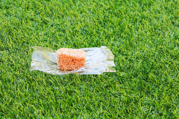 barretta di semi di sesamo cosparsa sulla farina di grano tenero. caramelle dolci thailandia antica in erba artificiale sfondo
 - Foto, immagini