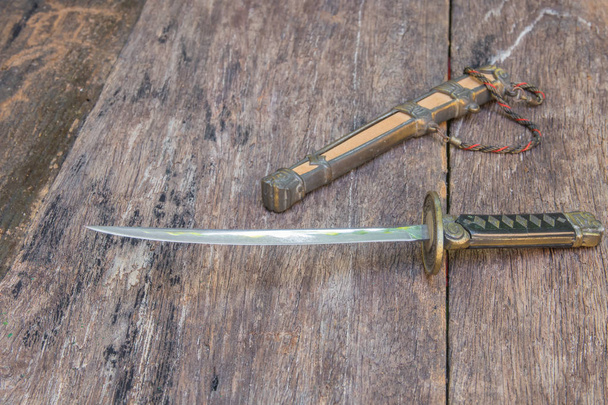 espada samurai lâmina de aço e cavalete de bainha antiga no piso de superfície de madeira velha com espaço de cópia
 - Foto, Imagem
