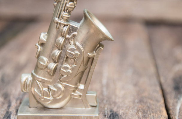 Saksofoni koristella vanha lähikuva vintage puinen tausta kopioi tilaa lisätä tekstiä
 - Valokuva, kuva