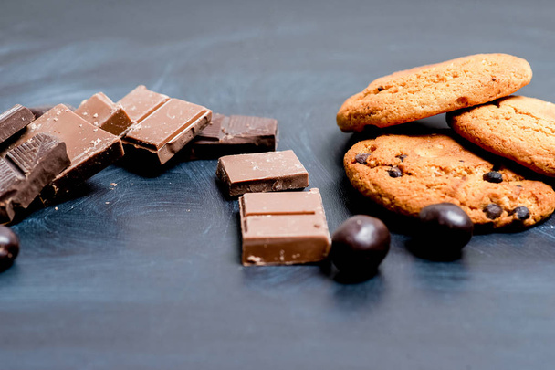 chocolate bar, shavings and cookies on a table - Фото, зображення