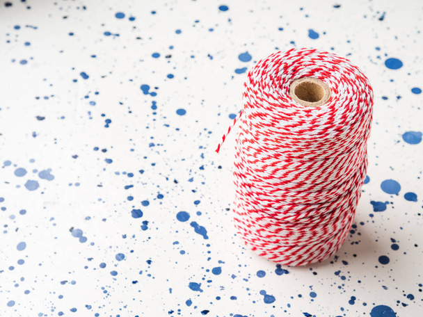 Red twine string roll on white background. Accessory for wrapping gifts - Foto, Imagen