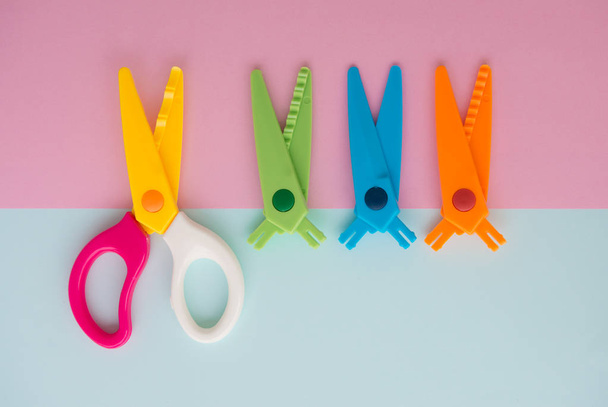 Minimal flat lay concept of colourful scissors with separate the blade for changing on the colorful background with copy space - Fotografie, Obrázek