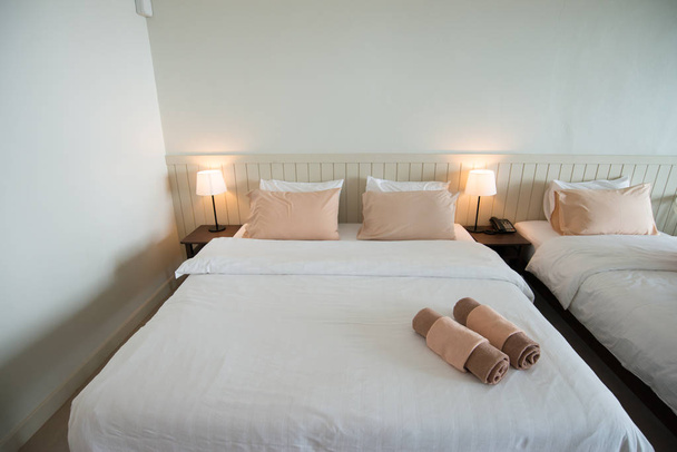 Біле ліжко з рушниками в номері в готелі
 - Фото, зображення
