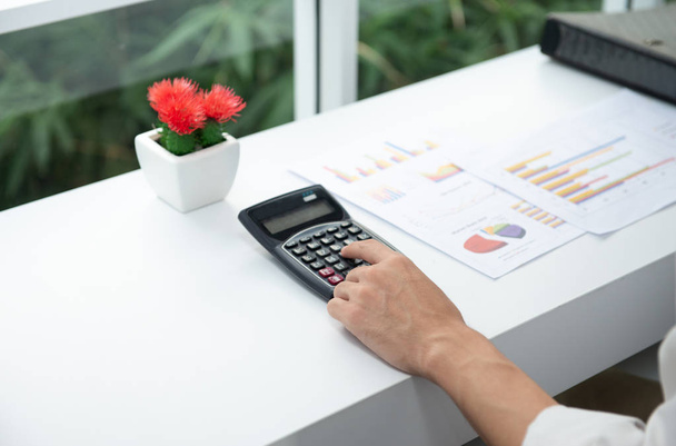 Крупним планом бізнес-леді використовує калькулятор для розрахунку прибутку бізнесу
 - Фото, зображення