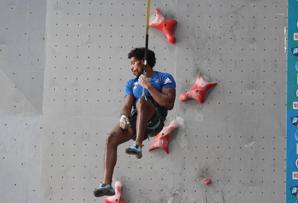 Bassa Mawem of France competes in the men's speed season final match during the 2018 International Federation of Sport Climbing (IFSC) World Cup tournament in Xiaman city, southeast China's Fujian province, 28 October 2018. - Photo, Image