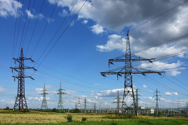 a zöld mezőben villamosenergia-oszlop - Fotó, kép