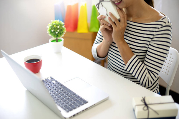 женщина сидит за компьютерным столом посмотреть на продукт пакет открытой или упаковки тему о покупке онлайн продажи и купить заказ
 - Фото, изображение