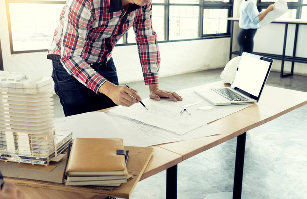 Architekt oder Ingenieur, der am Tisch arbeitet, zeigt Hand in Hand für Geschäftsprojekt, mit weißem Computerbildschirm mit Clipping-Pfad - Foto, Bild