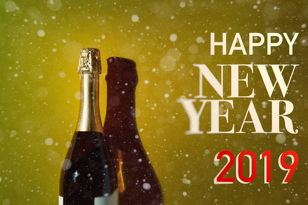 Merry Christmas and Happy new year 2019 Concept. Bottle of champagne on yellow  background, flat lay with text - Foto, imagen