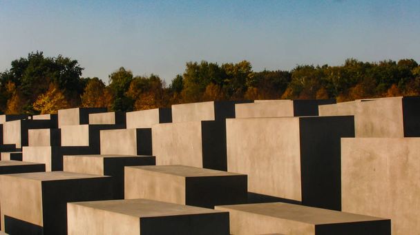 Side angle view of the Memorial of the murdered Jews of Europe or the Holocaust Memorial overlooking fall trees in Berlin, India - Foto, immagini