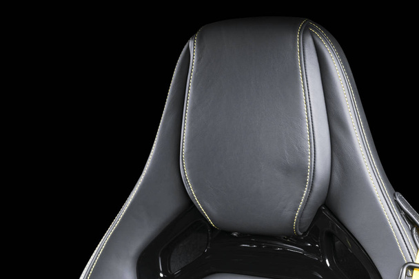 Black leather interior of the luxury modern car. Perforated Leather comfortable seats with yellow stitching isolated on black background. Modern car interior details. Car detailing. Car inside - Photo, Image