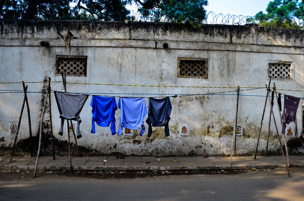 clothes hanging on makeshift tents in streets of central delhi. - Photo, image
