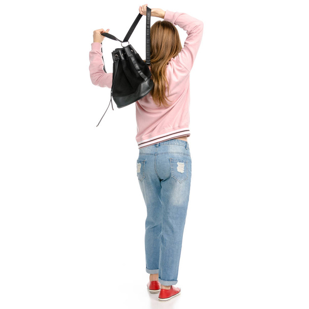 Beautiful woman in jeans with a backpack walking goes - Foto, imagen