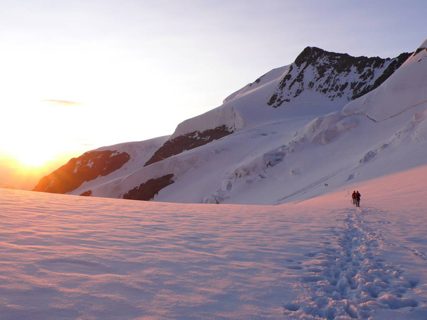 arrampicatore su una corda che attraversa un grande ghiacciaio nelle Alpi svizzere subito dopo l'alba nelle Alpi svizzere vicino a Pontresina
 - Foto, immagini