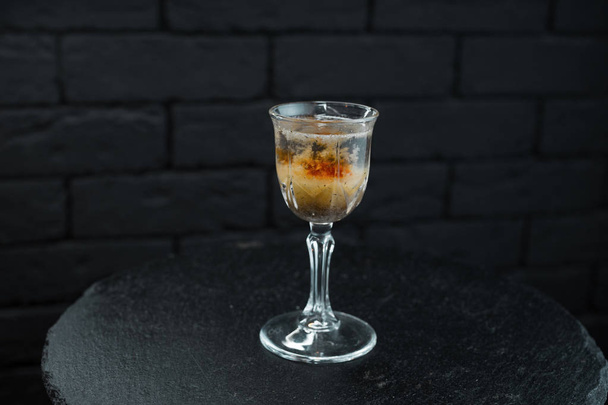Bardaki ahşap bir masa üzerinde bir kristal vintage bardak votka ve beyaz rom ile martini vermut ile ile inanılmaz bir alkollü içki duruyor. Harika hafta sonu - Fotoğraf, Görsel