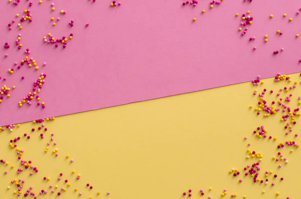 Cukorral megszórjuk pontok rózsaszín és sárga háttér, a díszítés a torta és a pékség. - Fotó, kép