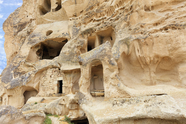 Many corridors and rooms are hollowed out in an old antique rock in the valley of Cappadocia, close-up view. - Photo, Image