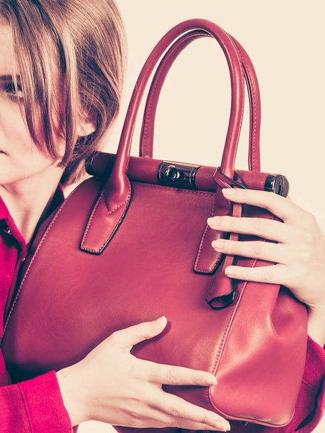 Woman protecting her handbag from thieves. Youn female guarding expensive leather bag - Photo, Image