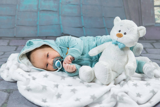 Cute baby boy with teddy bear in bed - Photo, Image