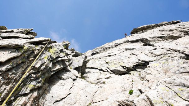 rock climber rappelling on a climbing route in the Alps of Switzerland - Photo, Image