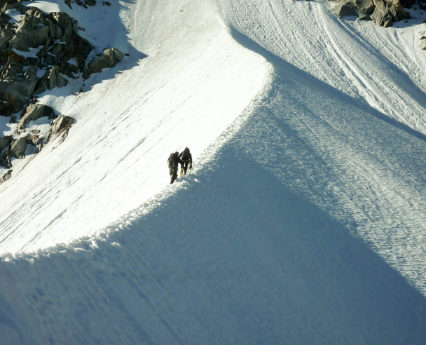 alpinistów na wąskie snow ridge na strome trasy wspinaczkowe w Alpach Francuskich, w Chamonix - Zdjęcie, obraz