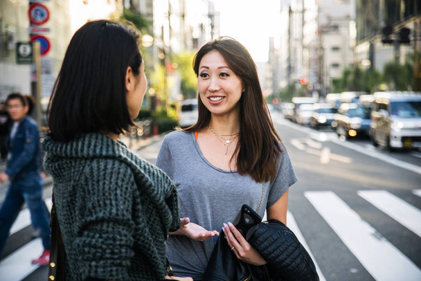 Dwie dziewczyny, spotkania na świeżym powietrzu i zabawy - Japończycy klejenie na ulicach Tokio - Zdjęcie, obraz