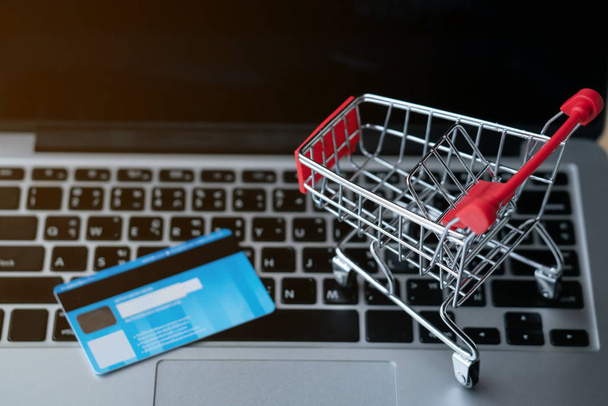 Bilgisayarda alışveriş arabası ve beşik kartı, online alışveriş konsepti. - Fotoğraf, Görsel