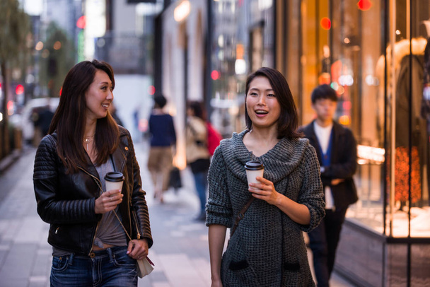 Two girlfriends meeting outdoors and having fun - Japanese people bonding on Tokyo streets - Valokuva, kuva