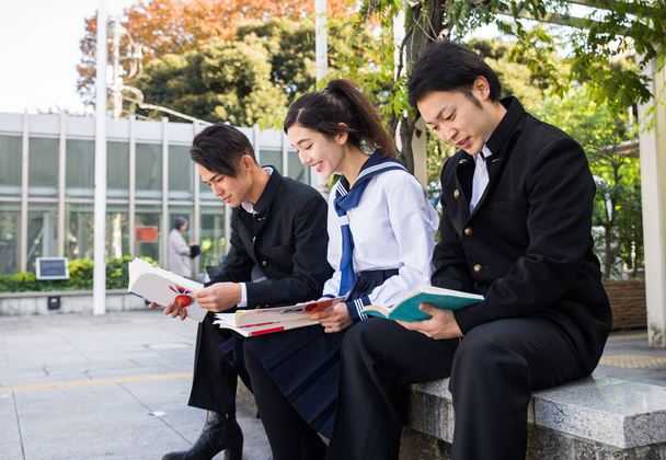 Yung japanese students with school uniform bonding outdoors - Group of asian teenagers having fun - 写真・画像