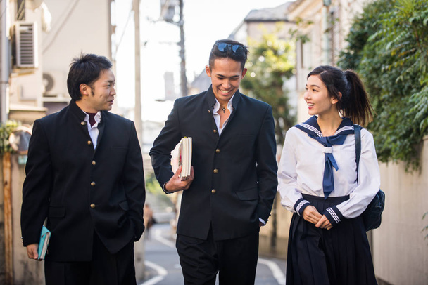 Yung japanese students with school uniform bonding outdoors - Group of asian teenagers having fun - Fotografie, Obrázek