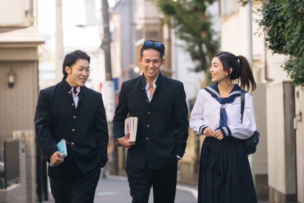 De Japanse studenten yung met school uniform verlijmen buitenshuis - groep van Aziatische tieners plezier - Foto, afbeelding