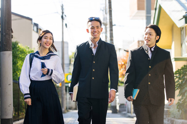 Yung japanese students with school uniform bonding outdoors - Group of asian teenagers having fun - Fotó, kép