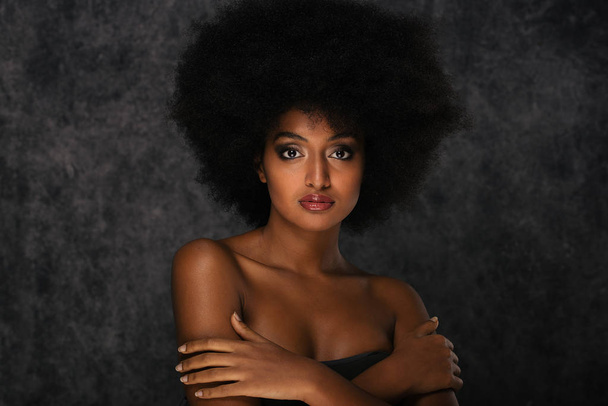 Portrait of pretty afro american woman in a studio for a beauty session - Beautiful girl posing on colored background - Foto, imagen