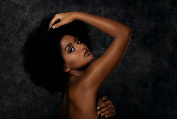 Portrait of pretty afro american woman in a studio for a beauty session - Beautiful girl posing on colored background - Foto, imagen