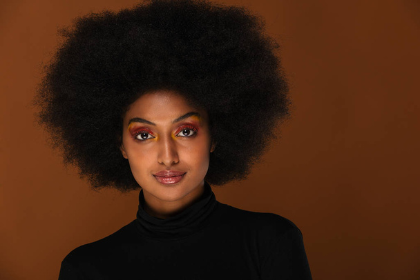 Retrato de una mujer afroamericana bonita en un estudio para una sesión de belleza - Hermosa chica posando sobre un fondo de color
 - Foto, Imagen