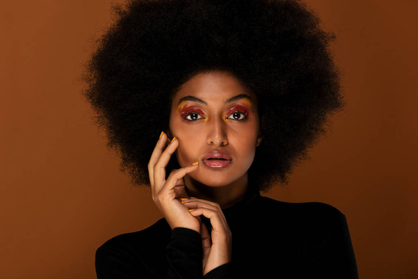 Portrait of pretty afro american woman in a studio for a beauty session - Beautiful girl posing on colored background - Foto, Imagen