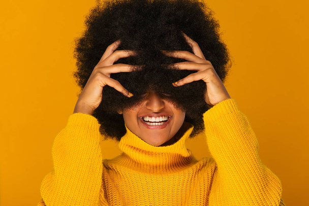 Porträt einer hübschen Afroamerikanerin in einem Studio für eine Beauty-Session - schönes Mädchen posiert auf farbigem Hintergrund - Foto, Bild