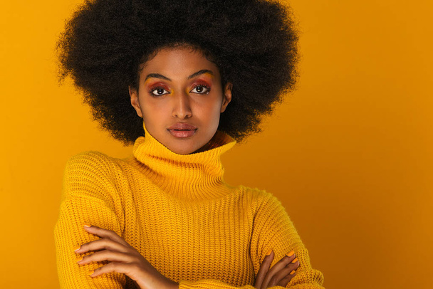Portrait of pretty afro american woman in a studio for a beauty session - Beautiful girl posing on colored background - Photo, image
