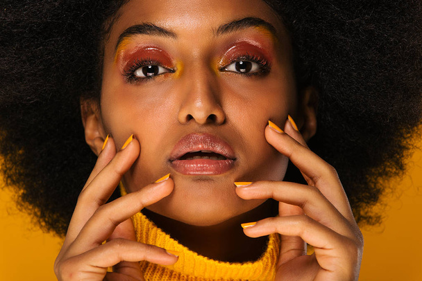 Porträt einer hübschen Afroamerikanerin in einem Studio für eine Beauty-Session - schönes Mädchen posiert auf farbigem Hintergrund - Foto, Bild