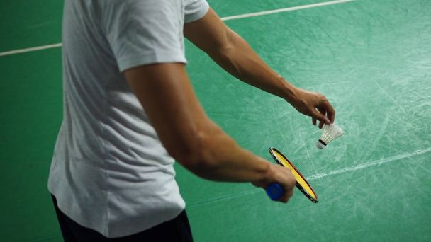 Erkek badminton oyuncu sol kolunda bazı damarlı bir hizmet için hazırlanıyor. (seçili odaklama) - Fotoğraf, Görsel