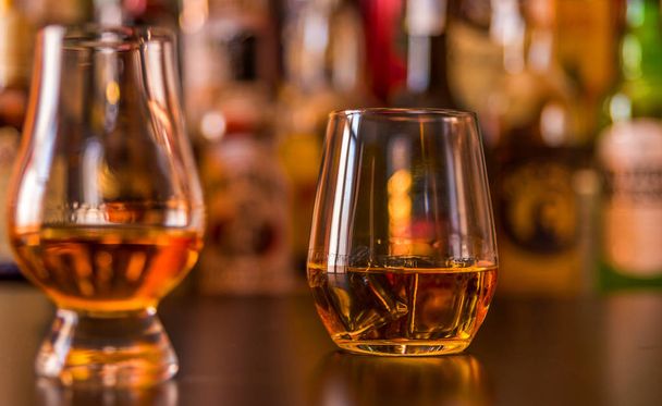 Scottish whisky in a glass with ice cubes, golden color whiskey, exclusive drink - 写真・画像