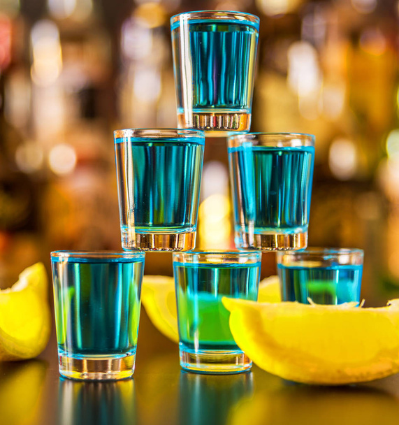 beliebtes blaues Getränk schoss Kamikaze auf den Hintergrund der Bar mit Flaschen, ein erfrischendes Getränk, Partynacht - Foto, Bild