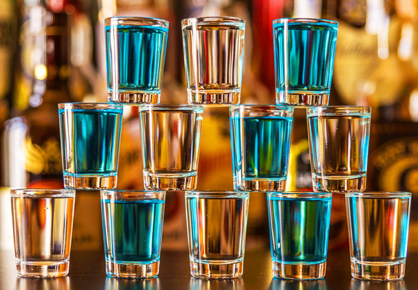 Popular blue drink shot kamikaze on the background of the bar with bottles, a refreshing drink, party night - Photo, Image