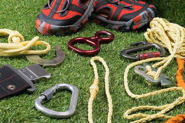 safety ropes for mountains and red shoes on green grass, background - Foto, Imagen
