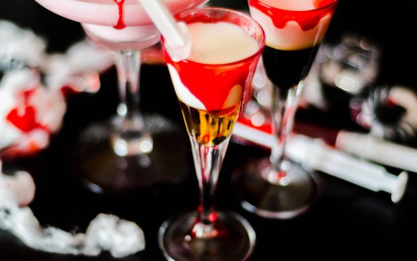 жуткие коктейли на Хэллоуин с кровью, пауками и кубиками льда, напитки на вечеринке
 - Фото, изображение