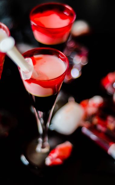creepy halloween party cocktails with blood, spiders and ice cubes, drinks at party - 写真・画像