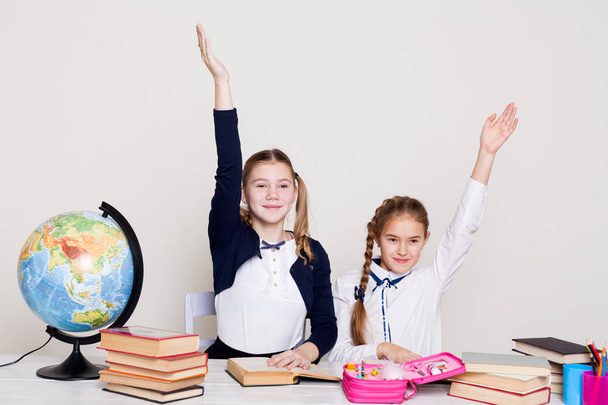 twee meisjes in de klas leren Les boeken op haar Bureau wereldbol - Foto, afbeelding