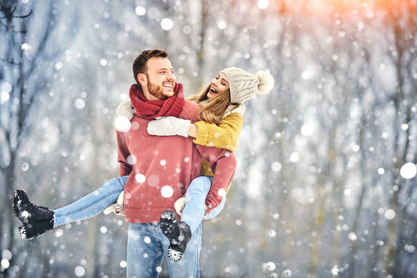 glückliches junges Paar im Winterpark, das lacht und Spaß hat. Familie im Freien. - Foto, Bild