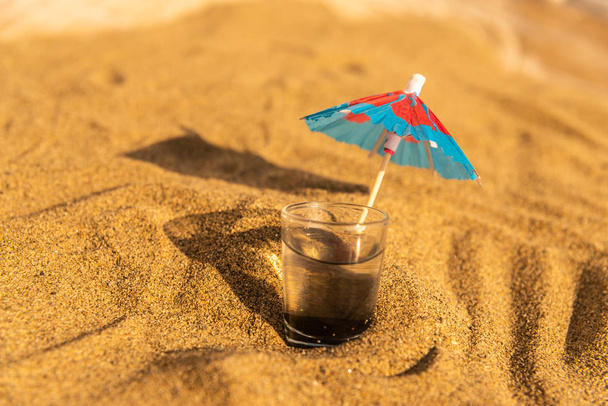 colorful shots drinks on a sandy beach with umbrellas for drinks, summer relax - Photo, Image