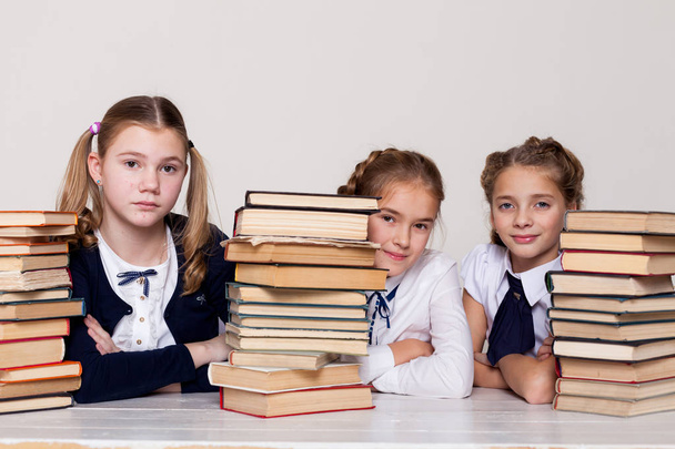 drie meisjes in de klas studeren veel boeken - Foto, afbeelding